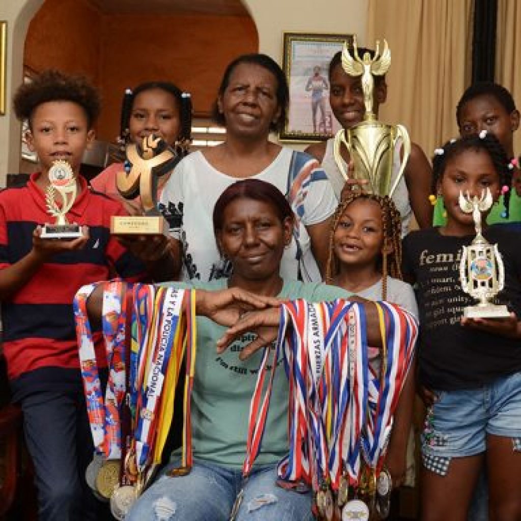 Madre  y familiares de Marileidy  Paulino con las madallas y trofeo ganado por la atleta
