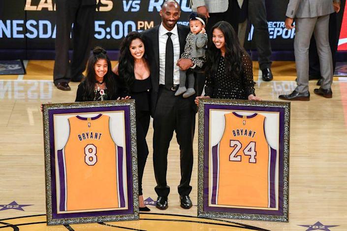 Kobe Bryant y su familia durante la ceremonia del retiro de los dos números que usó jugando en los Lakers